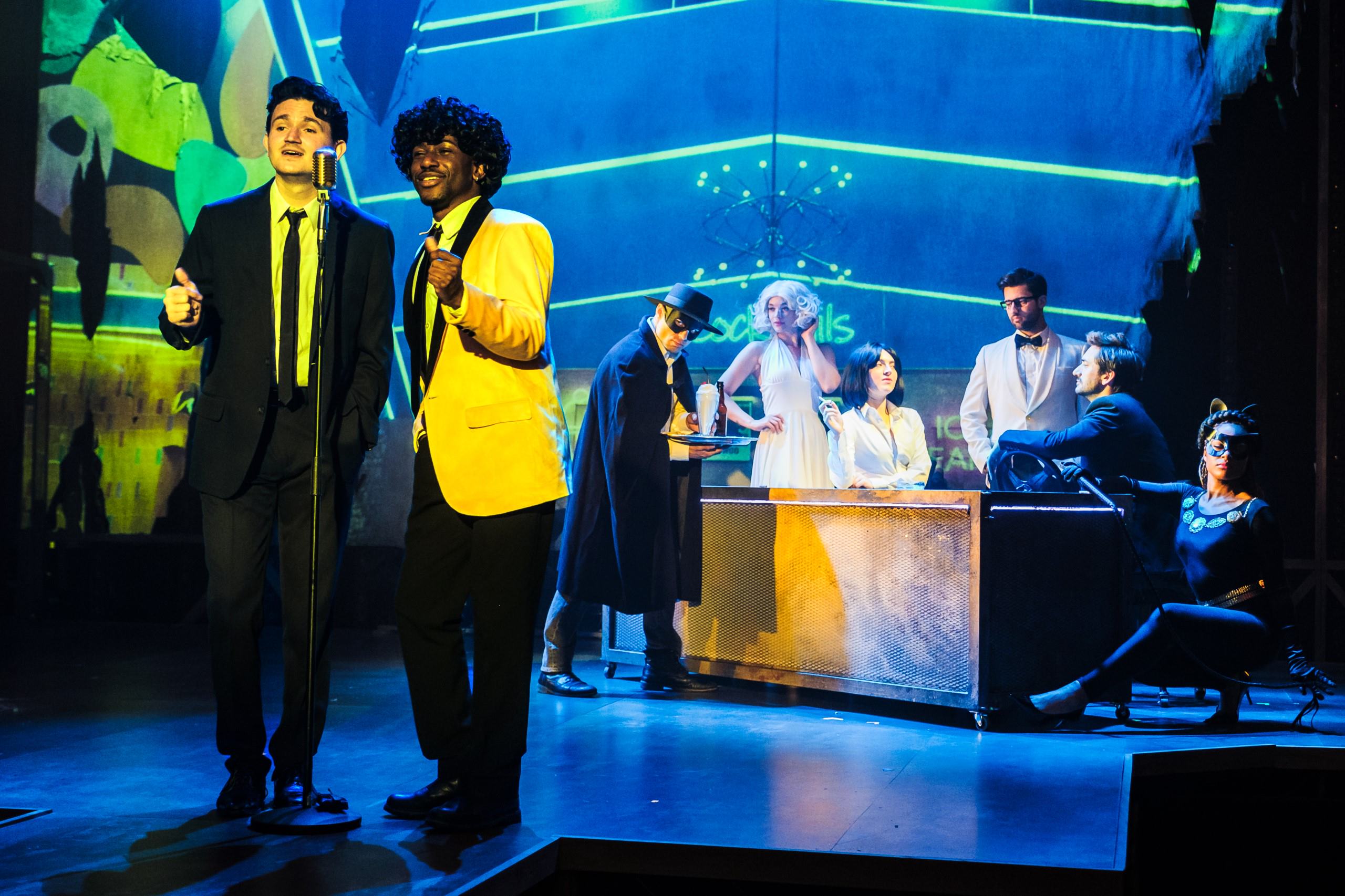 Two cast members singing on stage